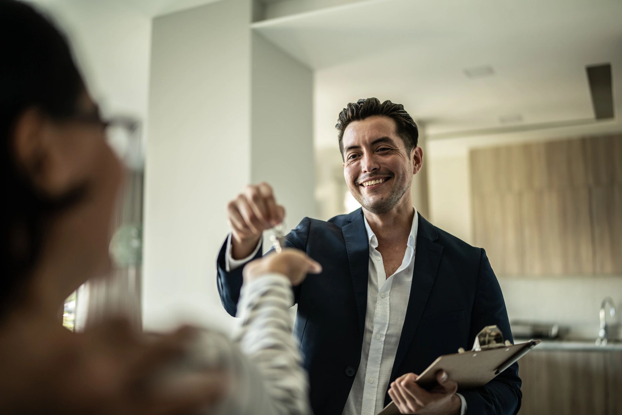 Mortgage professional handing keys to a new homeowner