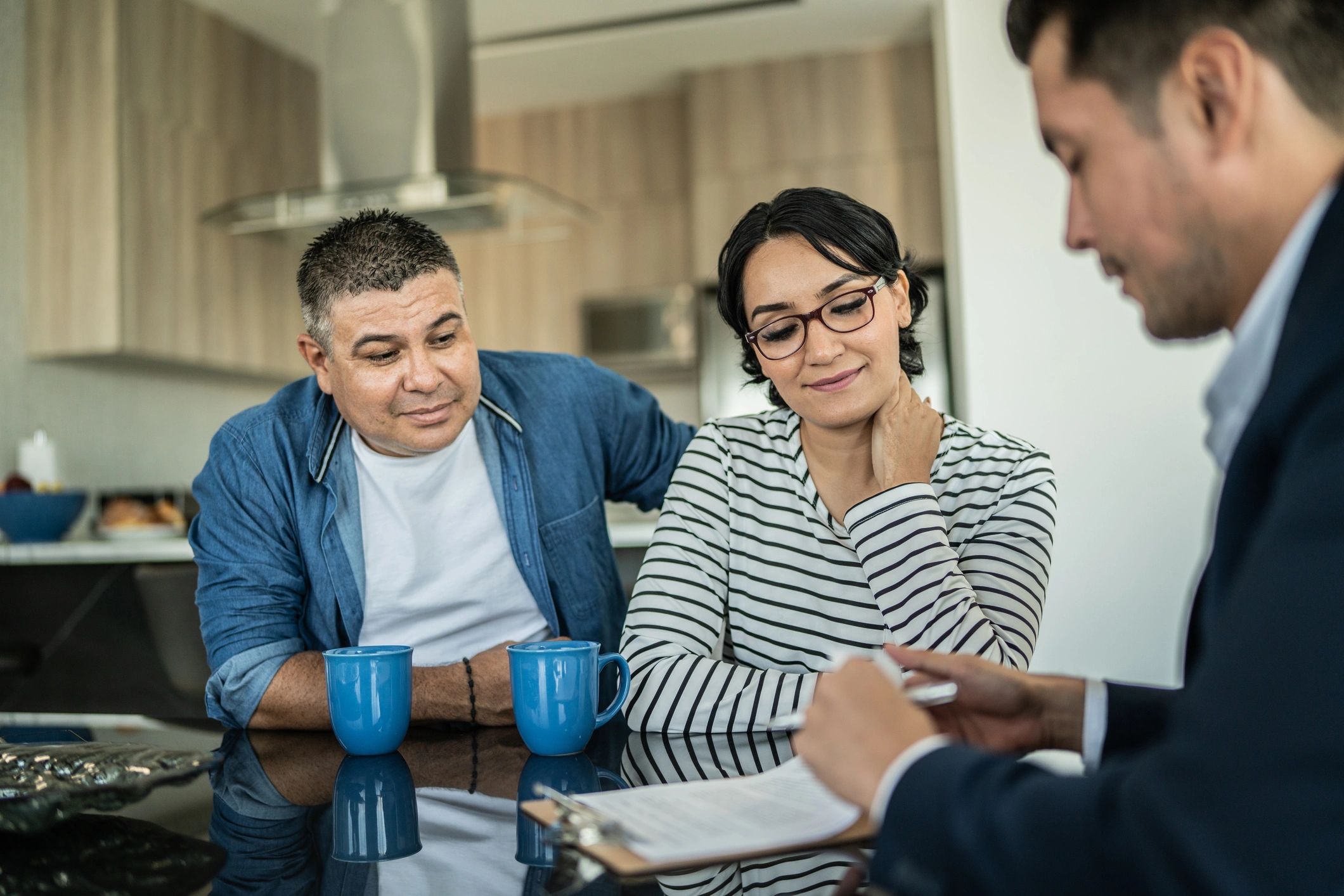 Mortgage professional meeting with a couple at a table