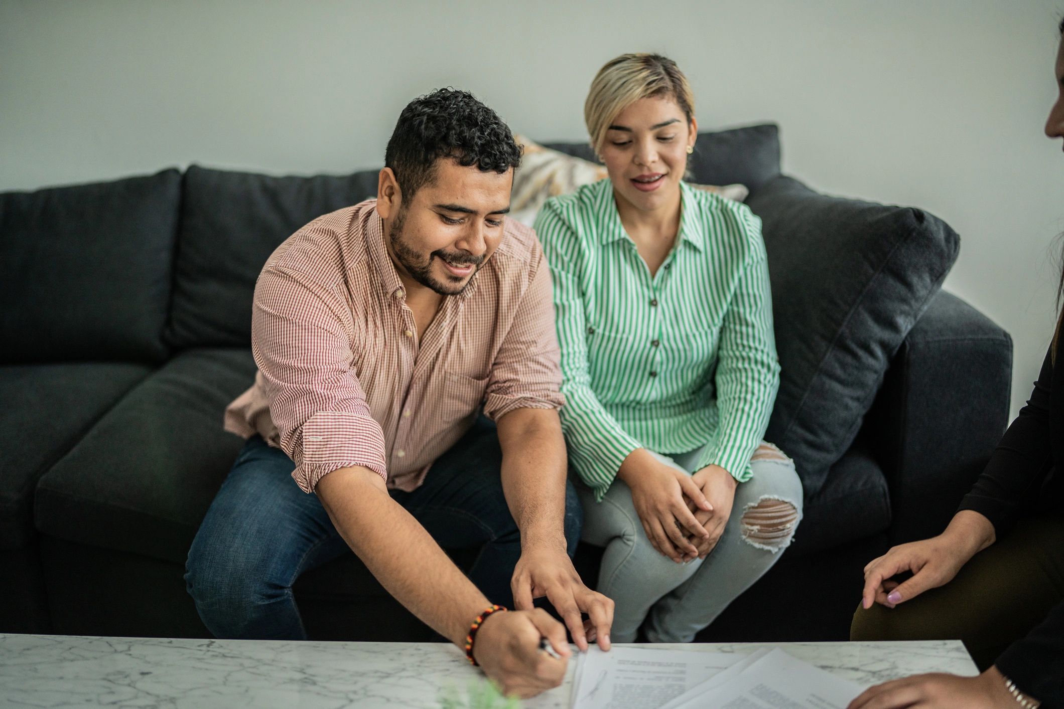 Homeowners signing refinance documents at a table