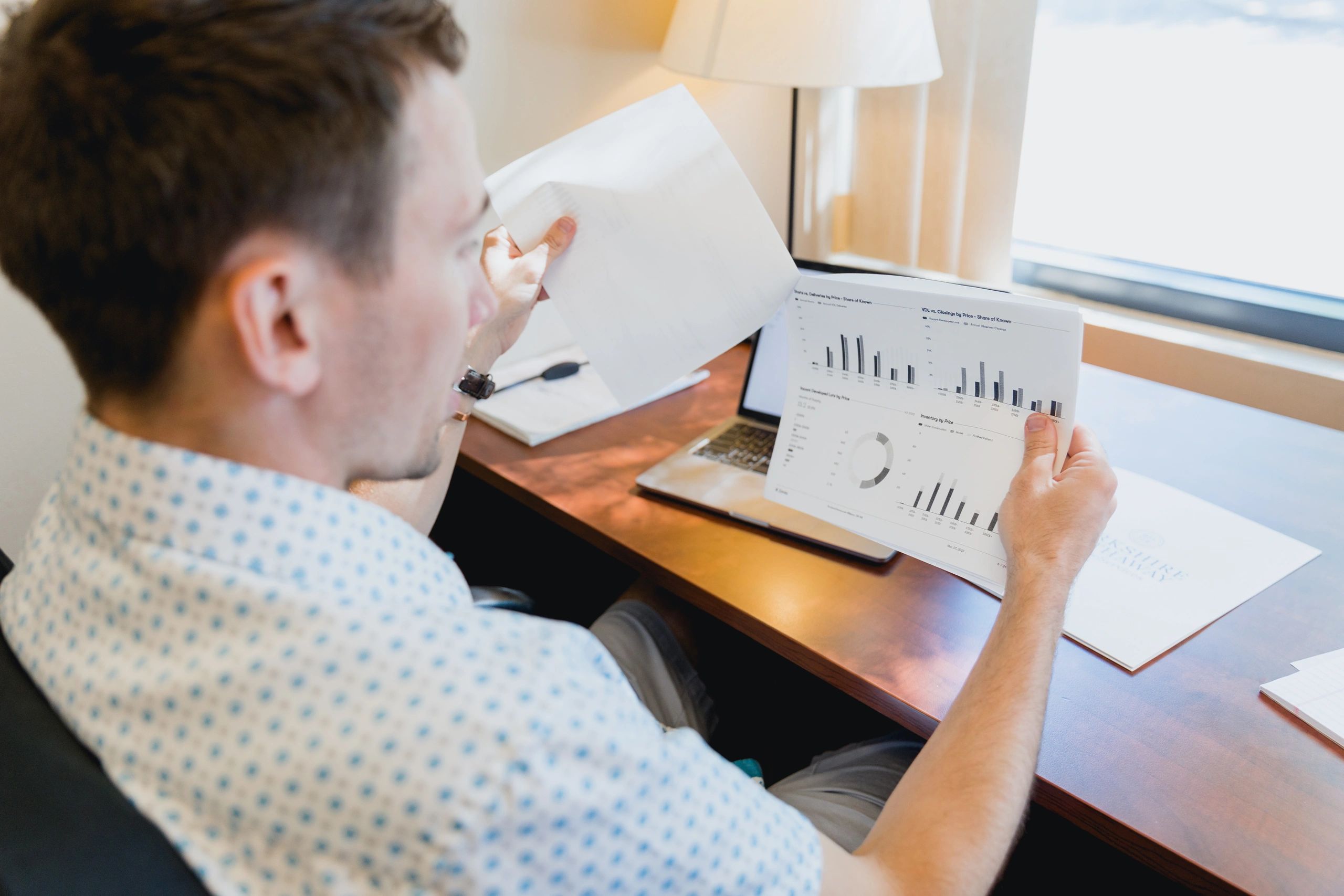 Real estate professional reviewing documents at a desk